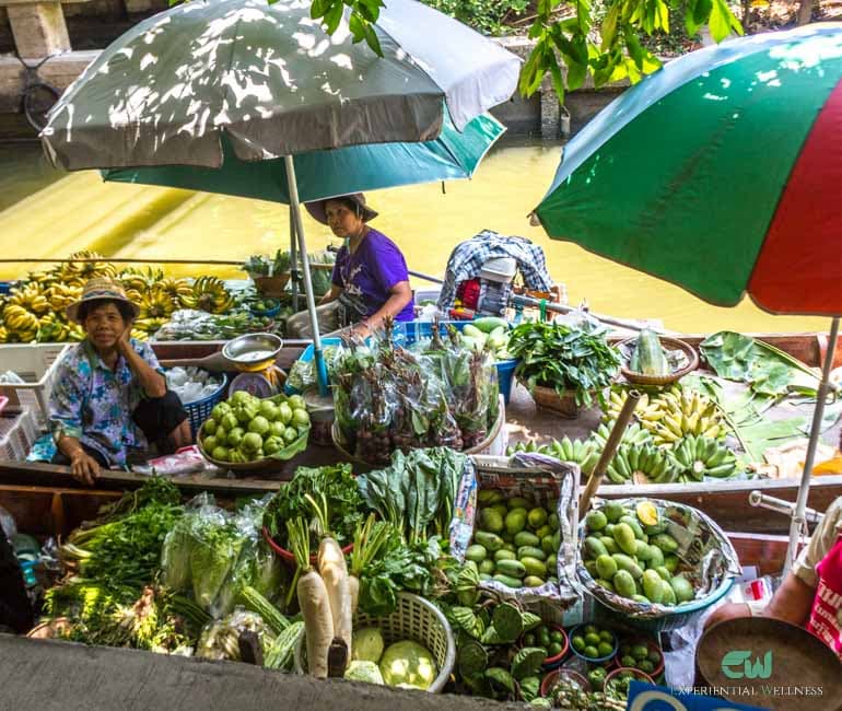 Tourists are bargaining with a local merchant at Lad Mayom Floating Market