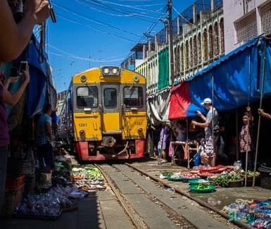 Train approaching the railway market in Thailand