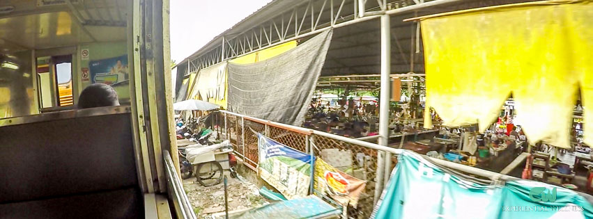 The train moves through a local market in Bangkok