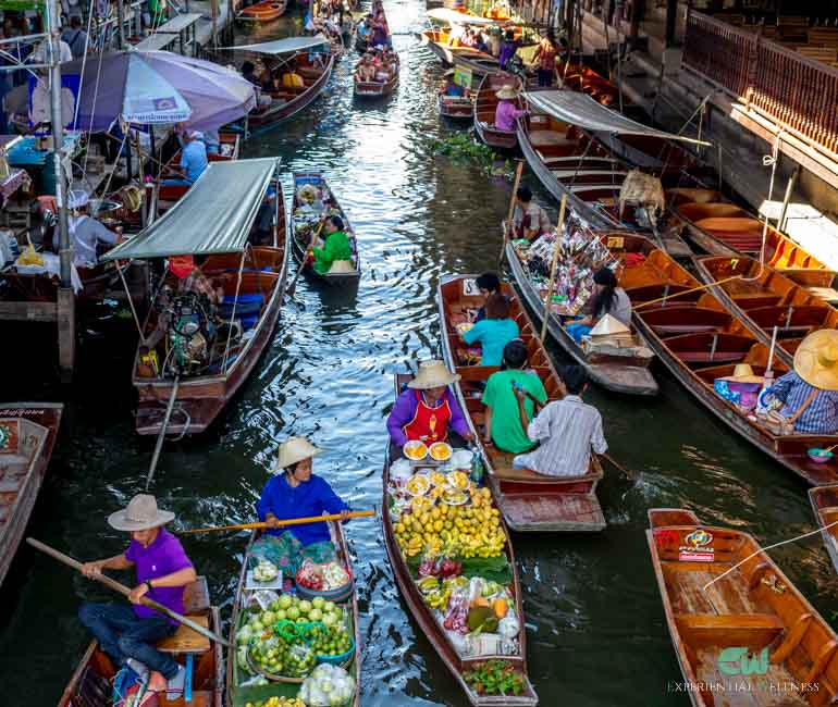 Thai merchants paddle their boat through the Damnoen Saduak canal