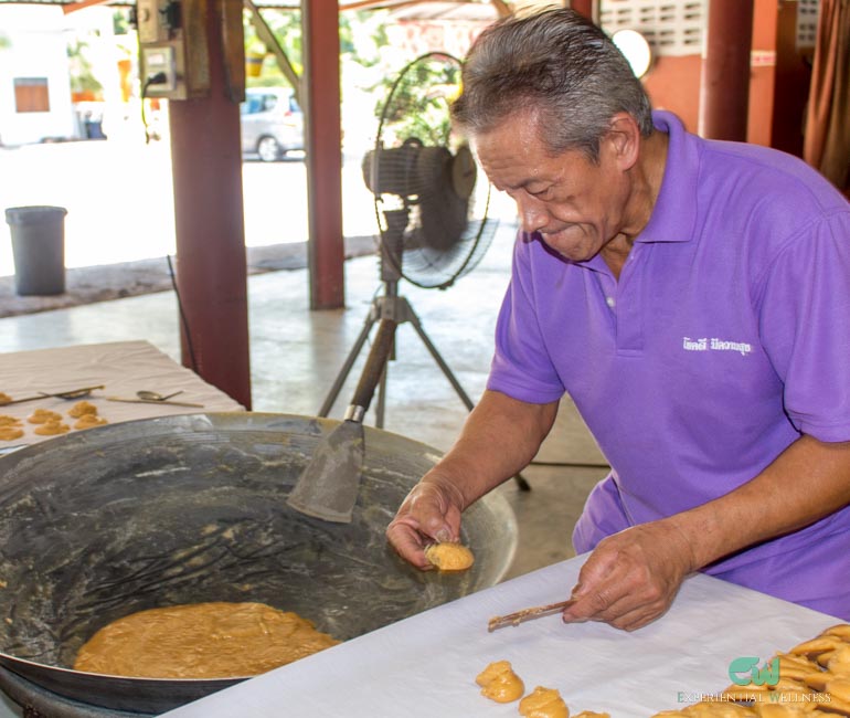 A Thai local is making coconut sugar snacks in Damnoen Saduak