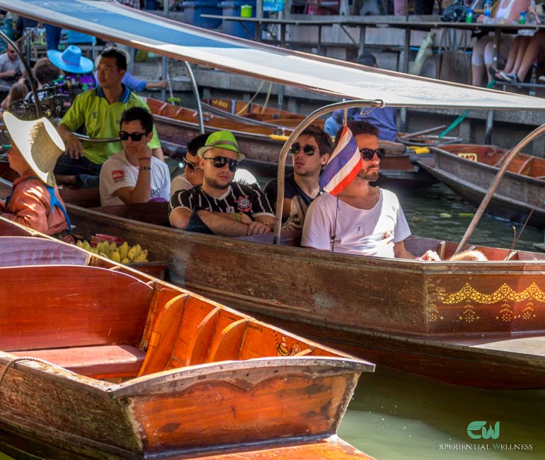 Tourists are seated on a long-tail boat