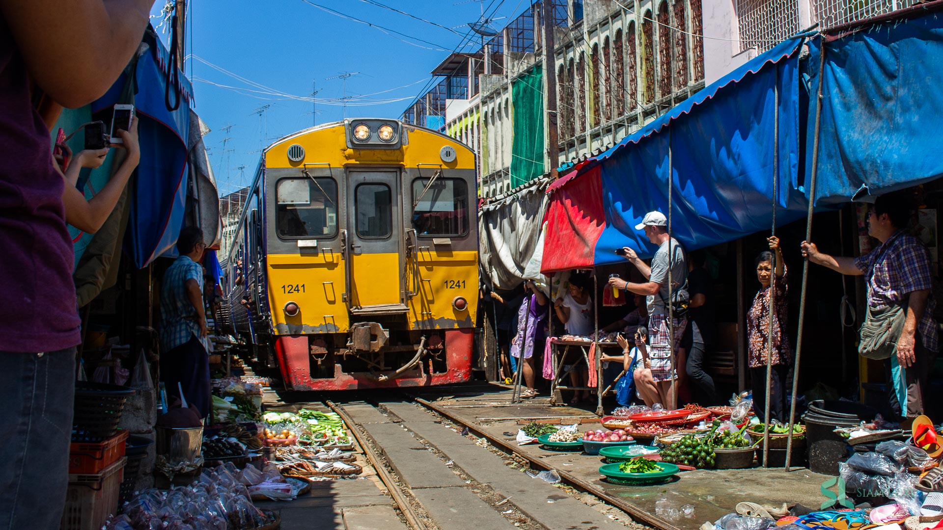 A train approaches through the Umbrella Pull-down Market