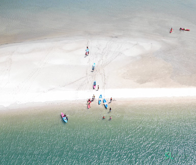 Drone taking a photo of travelers enjoying kayaking on an island in the Southern part of Thailand