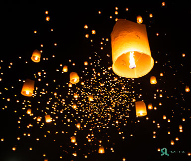 Buddhist laypeople and tourists release floating lanterns to the sky during the Yee Peng ceremony in Chiang Mai