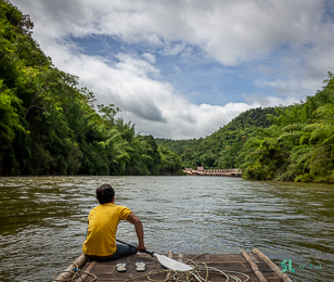 A tourist enjoys bamboo rafting in Kanchanaburi